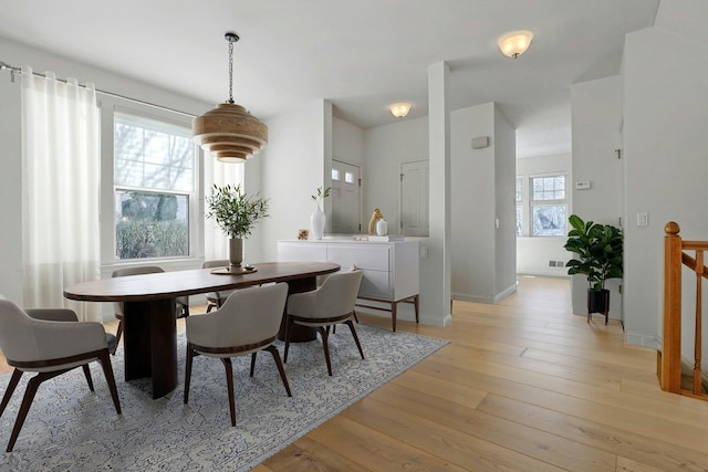 dining space featuring visible vents, light wood-style flooring, and baseboards