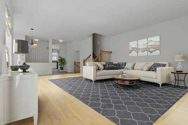 living area featuring a chandelier, stairway, and wood finished floors