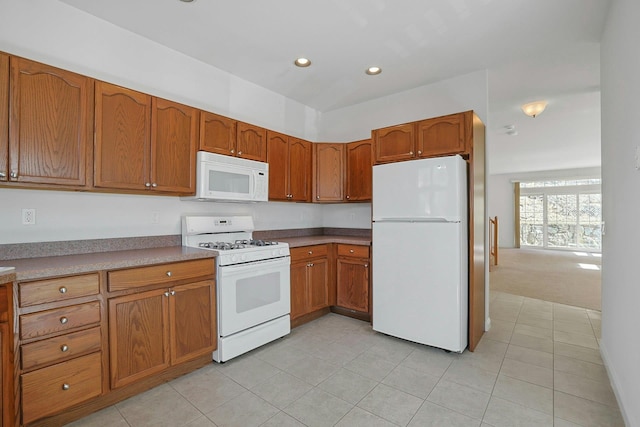 kitchen with light tile patterned floors, white appliances, recessed lighting, and brown cabinets