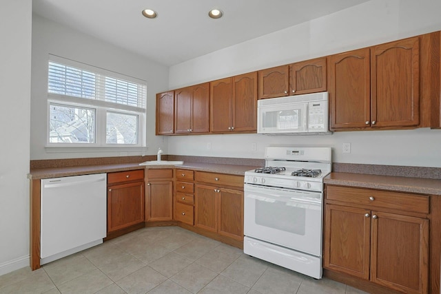 kitchen with brown cabinetry, recessed lighting, white appliances, and light tile patterned floors