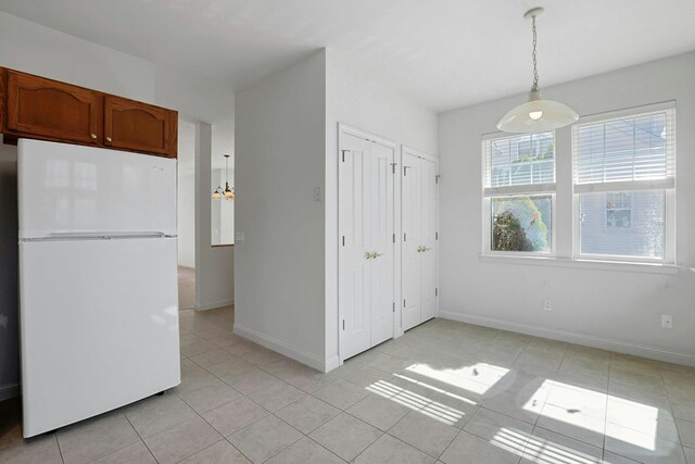 interior space with light tile patterned floors and baseboards