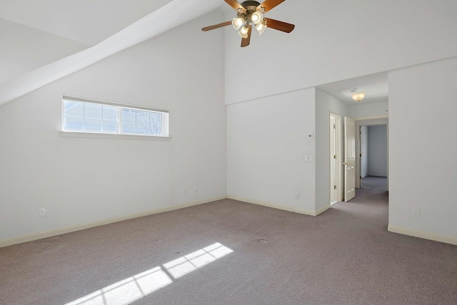 carpeted spare room featuring high vaulted ceiling, ceiling fan, and baseboards