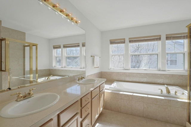 full bathroom with tile patterned flooring, a garden tub, a sink, and a shower stall