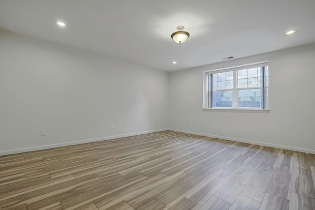 empty room featuring recessed lighting, visible vents, light wood finished floors, and baseboards