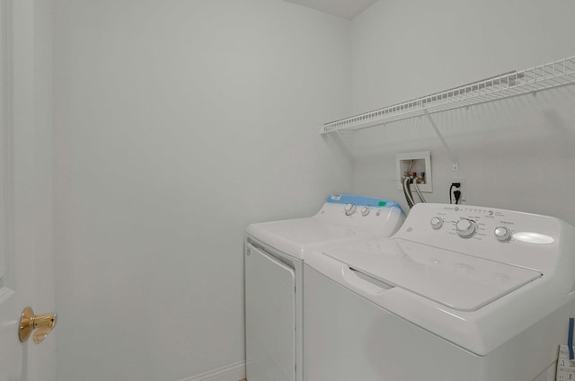 washroom featuring baseboards, laundry area, and washer and dryer