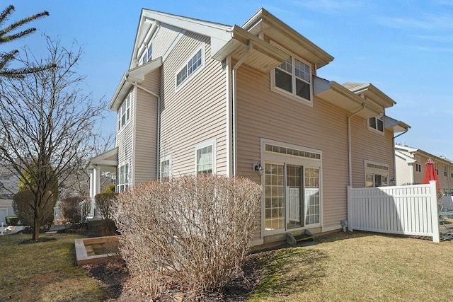 view of home's exterior with a yard and fence