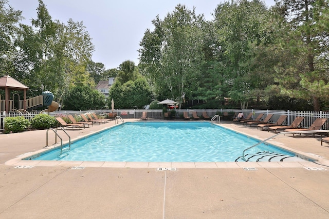 pool with a patio area and fence