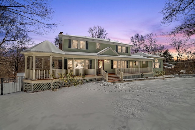 back house at dusk with covered porch