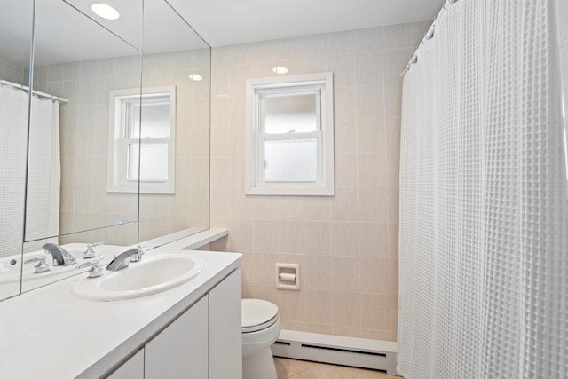 full bathroom with toilet, tile patterned flooring, baseboard heating, vanity, and tile walls