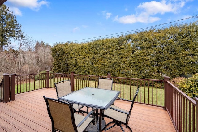 wooden deck with outdoor dining area and a lawn