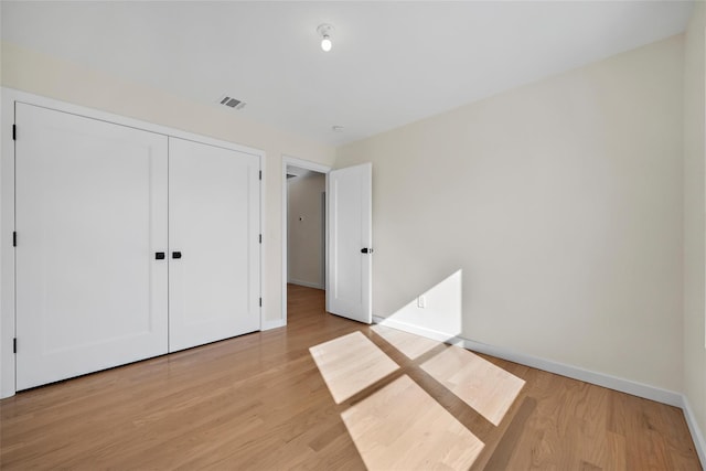 unfurnished bedroom featuring a closet and light hardwood / wood-style floors