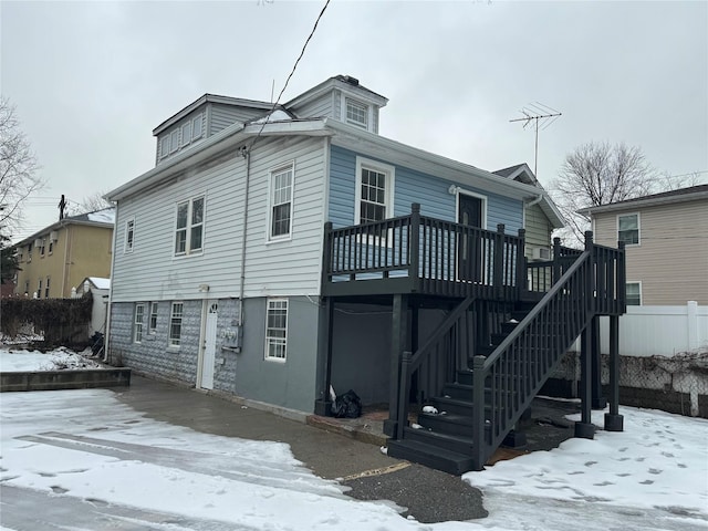 snow covered property with a deck