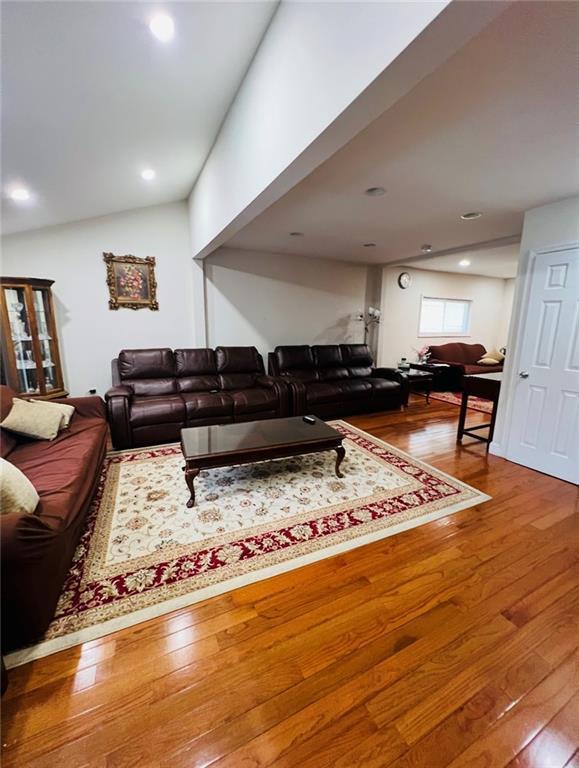 living room featuring hardwood / wood-style flooring and lofted ceiling