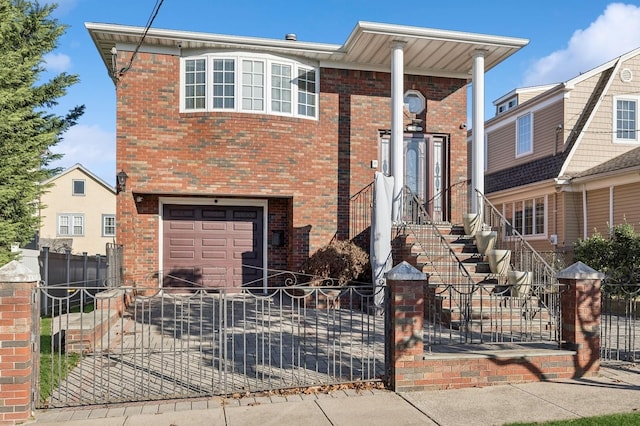 view of front facade with an attached garage, driveway, a fenced front yard, and brick siding