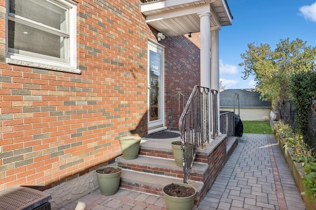 doorway to property with fence and brick siding