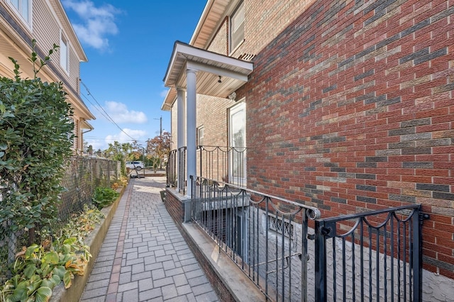 view of property exterior featuring fence and brick siding