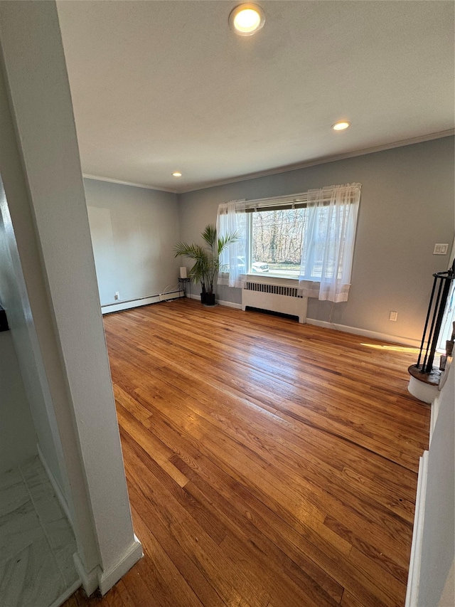 unfurnished room with a baseboard heating unit, baseboards, radiator heating unit, recessed lighting, and wood finished floors