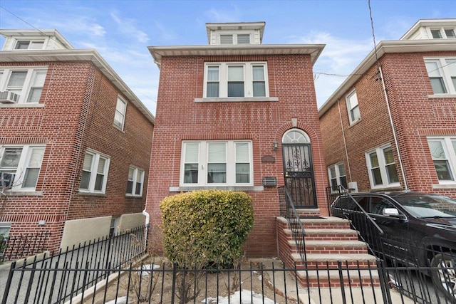 view of front of property with a fenced front yard and brick siding