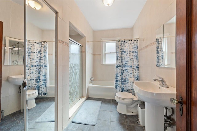 full bathroom featuring toilet, shower / bath combination with curtain, tile walls, and tile patterned floors