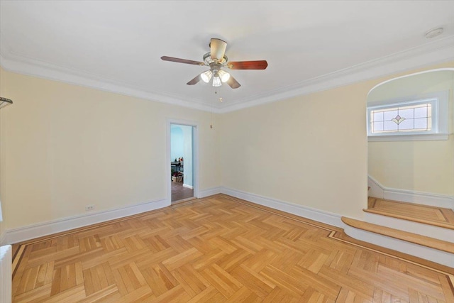 spare room featuring baseboards, ornamental molding, and ceiling fan