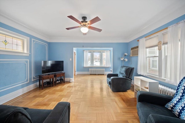 living room with ornamental molding, radiator, ceiling fan, and baseboards