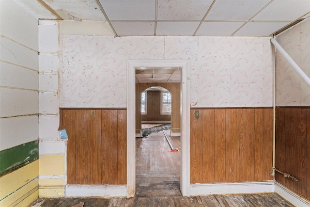 interior space featuring hardwood / wood-style flooring, a paneled ceiling, and wood walls