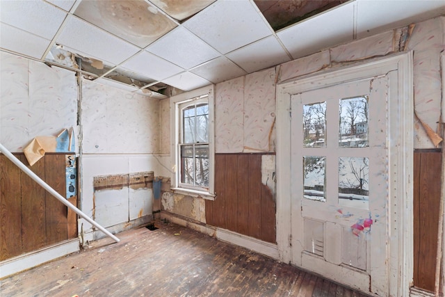 interior space with dark wood-type flooring and a drop ceiling