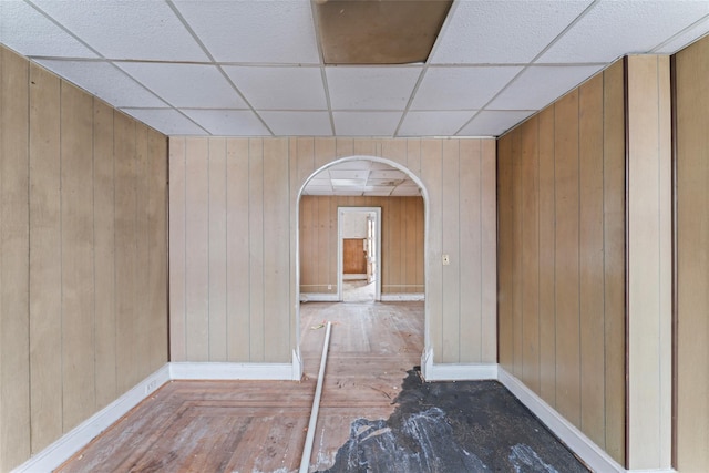 interior space with wooden walls and a drop ceiling