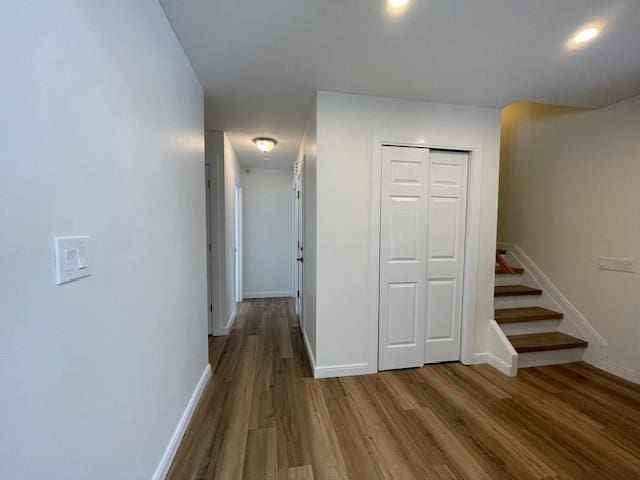 corridor with stairs, baseboards, and wood finished floors