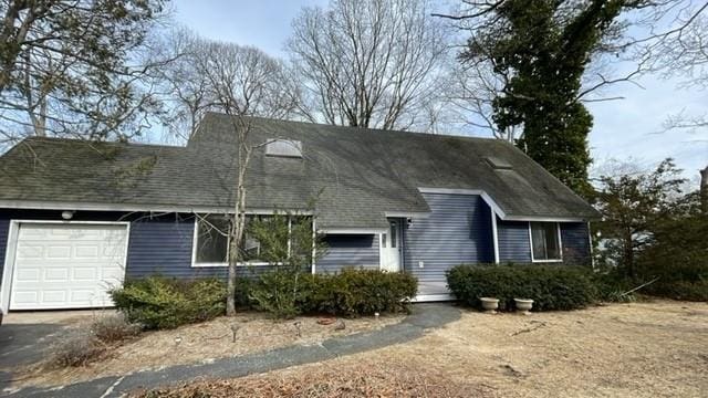 view of front of home featuring a garage, driveway, and a shingled roof