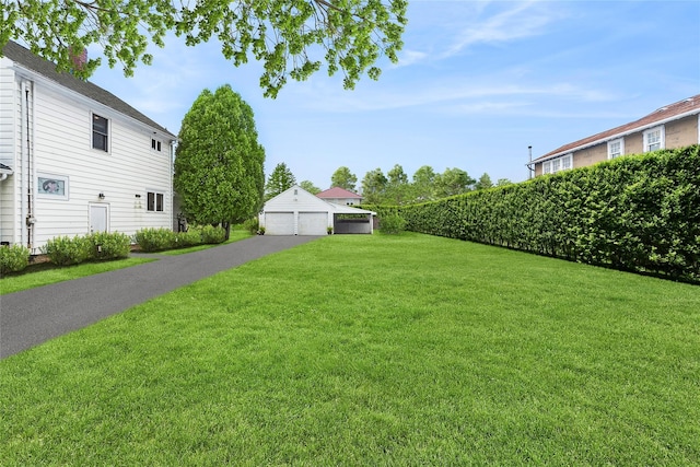 view of yard featuring a garage and an outbuilding