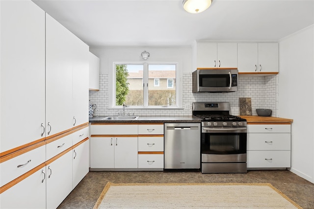 kitchen with sink, white cabinets, stainless steel appliances, and decorative backsplash