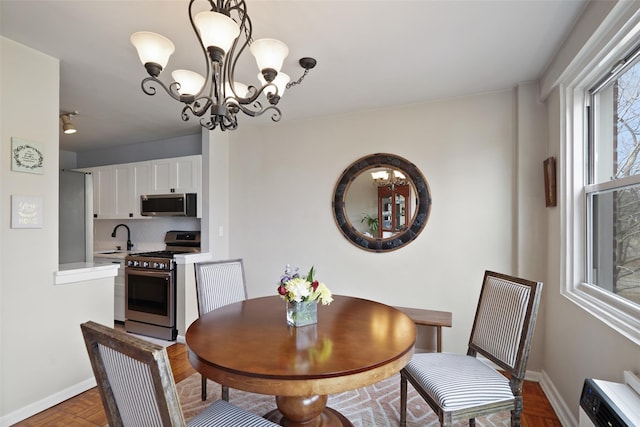 dining room featuring baseboards and an inviting chandelier