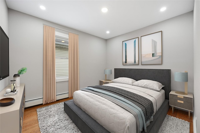 bedroom with light hardwood / wood-style flooring and a baseboard radiator