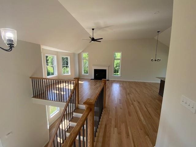 hall featuring lofted ceiling, hardwood / wood-style floors, and a chandelier