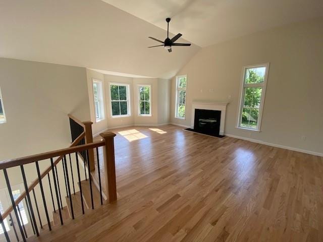 unfurnished living room featuring hardwood / wood-style floors, vaulted ceiling, and ceiling fan