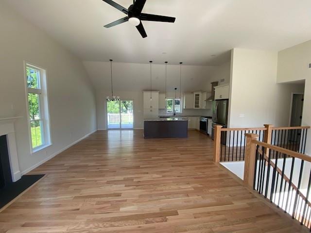 kitchen featuring a center island, white cabinets, light wood-type flooring, and decorative light fixtures