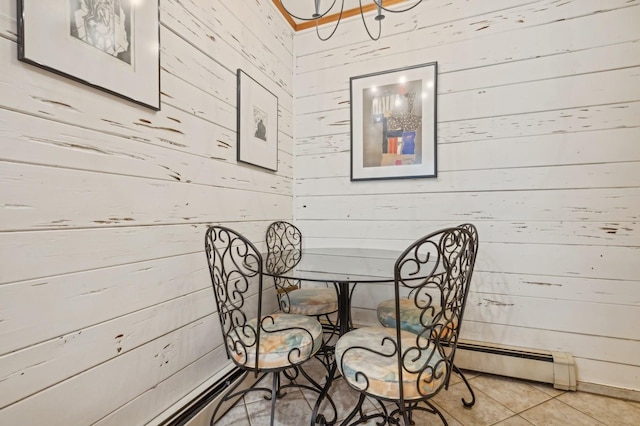 dining room with tile patterned floors, baseboard heating, and wood walls