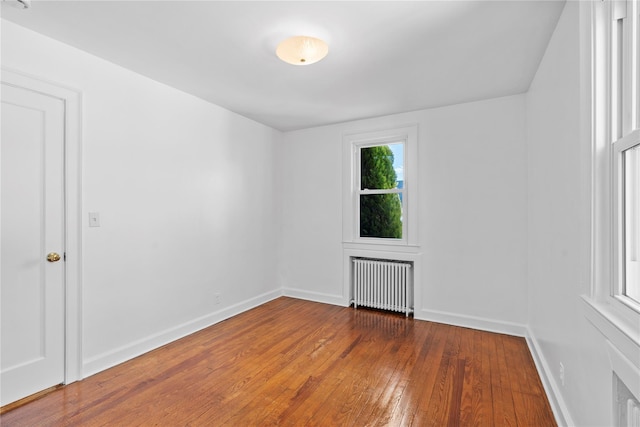 empty room with radiator and dark hardwood / wood-style floors