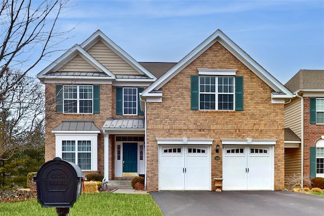 view of front facade featuring driveway, a standing seam roof, an attached garage, and metal roof