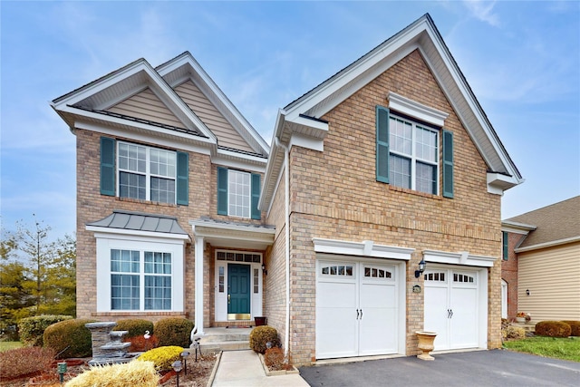 traditional home featuring a garage, driveway, and a standing seam roof