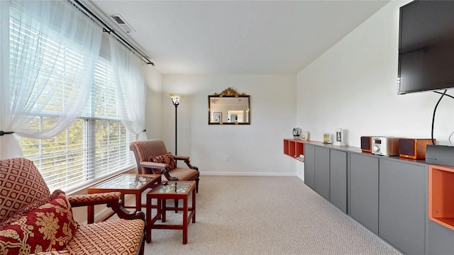 sitting room featuring light carpet, baseboards, and visible vents