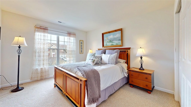 bedroom with light carpet, visible vents, and baseboards