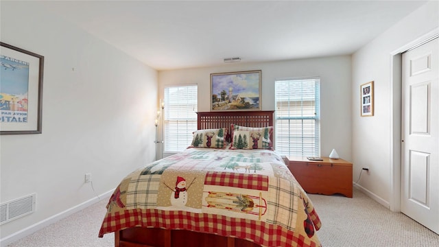 carpeted bedroom with multiple windows, visible vents, and baseboards