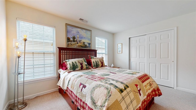 carpeted bedroom with baseboards and a closet