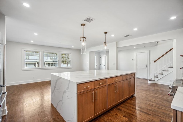 kitchen with visible vents, dark wood-style floors, light stone countertops, pendant lighting, and recessed lighting