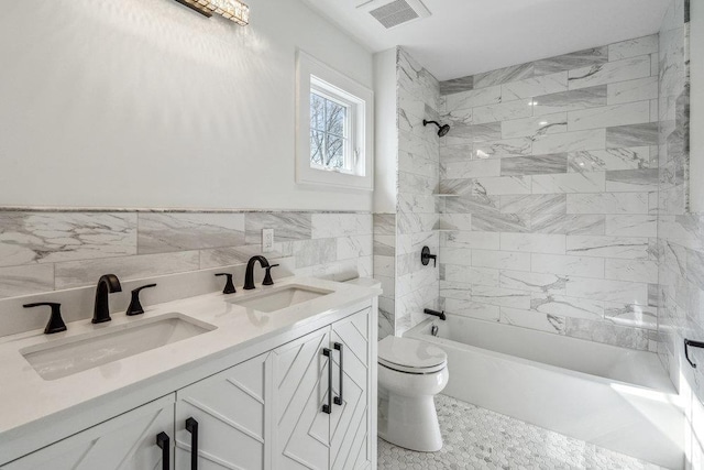 full bathroom featuring toilet, a sink, visible vents, and tile walls