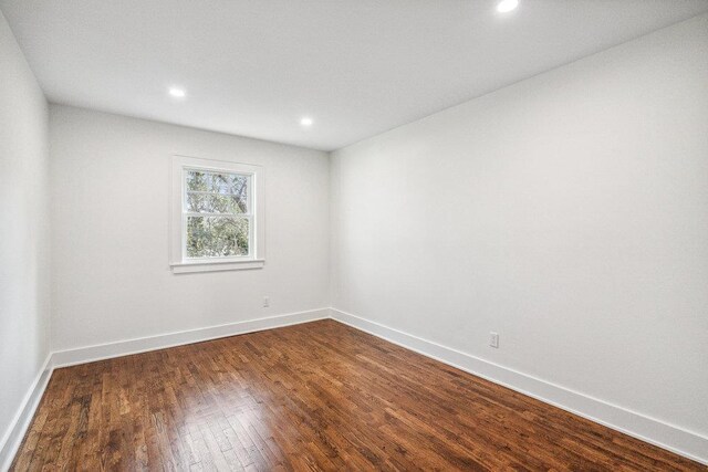 spare room featuring dark wood-style floors, baseboards, and recessed lighting