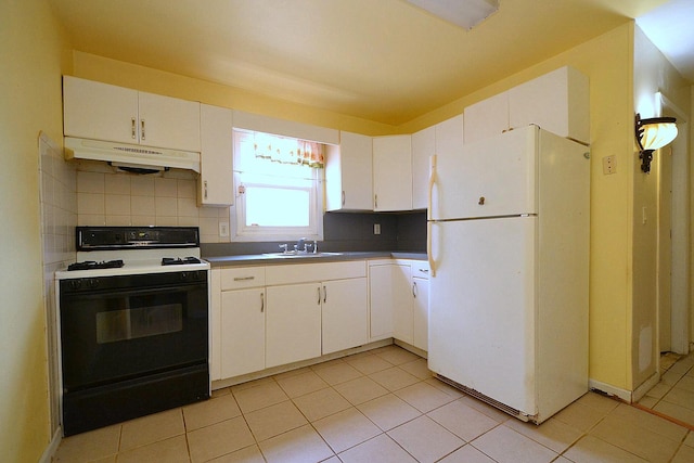 kitchen with tasteful backsplash, gas range, freestanding refrigerator, under cabinet range hood, and a sink