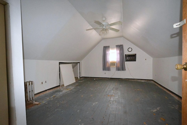 additional living space featuring ceiling fan, vaulted ceiling, radiator heating unit, and hardwood / wood-style flooring